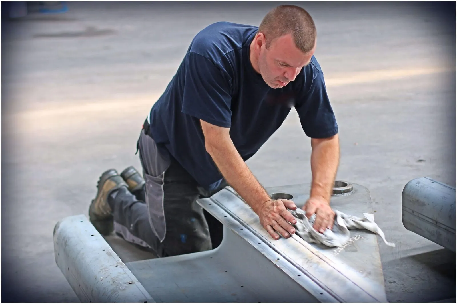 Technician inspecting a machined steel component before packing