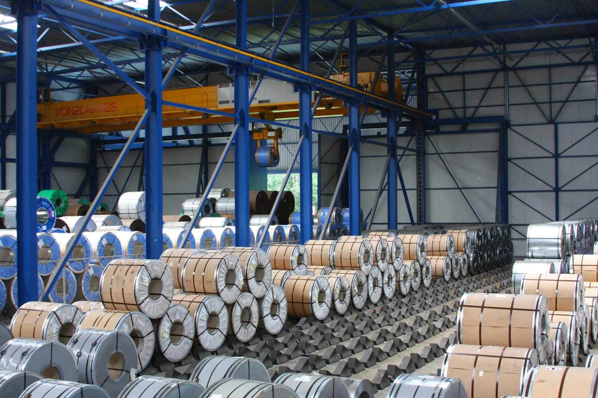 Steel coils stored under the overhead cranes in a Maasterminal warehouse